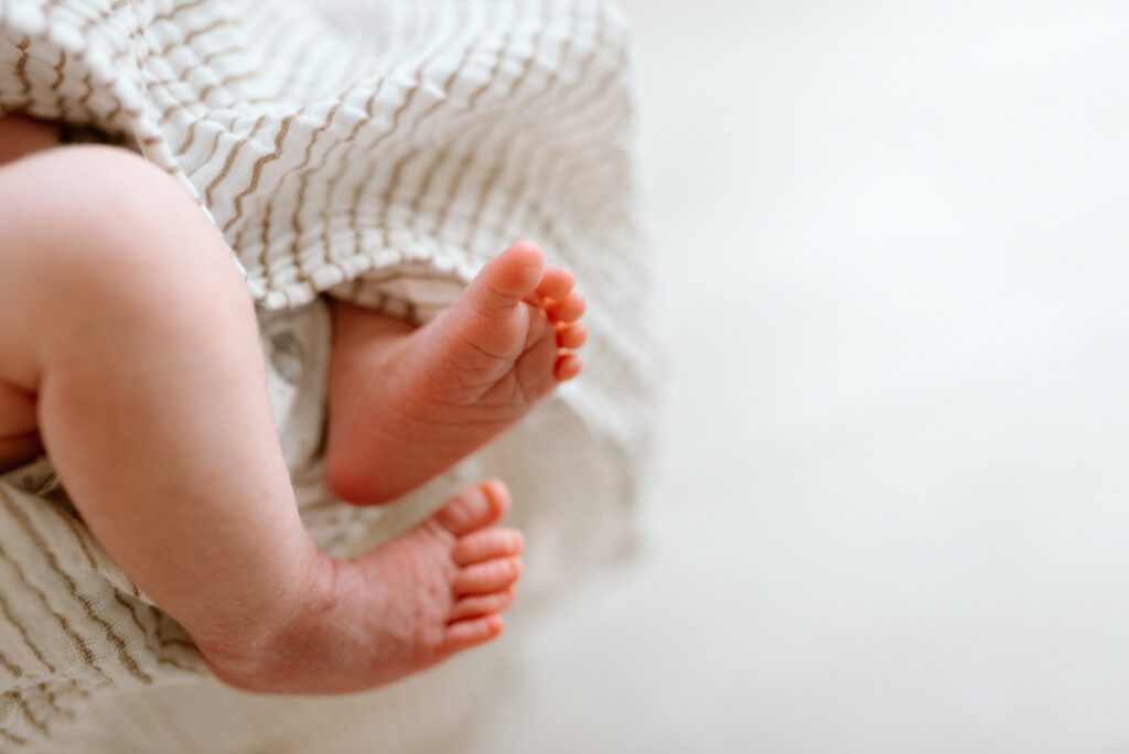 newborn baby feet poking out of a blanket