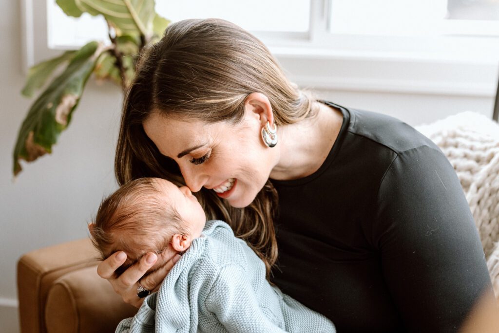 a mom snuggles nose to nose with her newborn baby